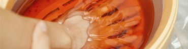 Hand being dipped in a warm paraffin wax bath